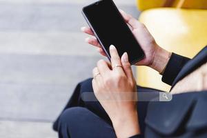 A businesswoman touches the screen of a mobile phone and a search page on the touch screen of a smartphone. photo