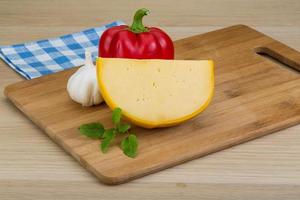 Yellow round cheese on wooden background photo