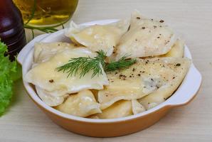 Vareniki in a bowl on wooden background photo