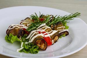 Aubergine roll on the plate and wooden background photo