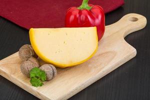 Yellow round cheese on wooden background photo