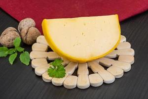 Yellow round cheese on wooden background photo