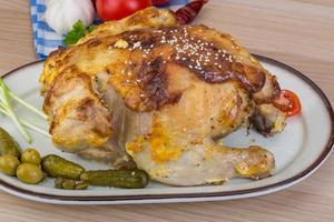 Grilled chicken on the plate and wooden background photo