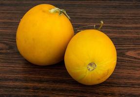 Small yellow melon on wooden background photo