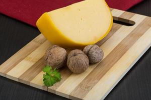 Yellow round cheese on wooden background photo