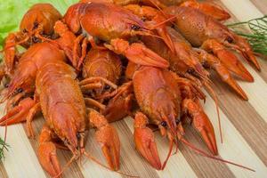 Boiled crayfish on wooden board and wooden background photo