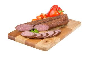 Sausages on wooden board and white background photo