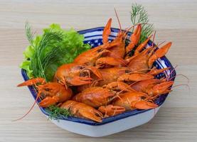 Boiled crayfish in a bowl on wooden background photo