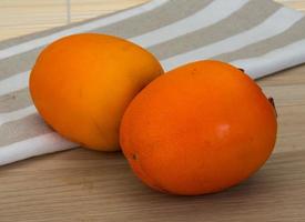 Persimmon on wooden background photo