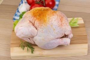 Raw chicken on wooden board and wooden background photo