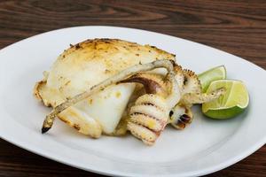 Grilled cuttlefish on the plate and wooden background photo