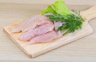 Raw chicken breast on wooden board and wooden background photo
