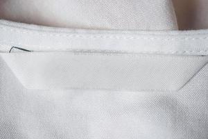 etiqueta de ropa blanca en blanco para el cuidado de la ropa en la camisa de algodón foto