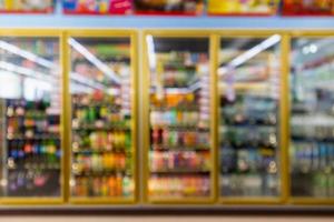 supermarket convenience store refrigerators with soft drink bottles on shelves abstract blur background photo