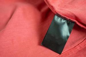 blank black color clothing label on red t shirt photo