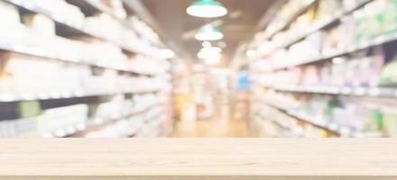 Wood table top with supermarket aisle blur background for product display photo