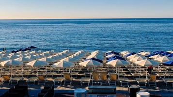 texture of umbrellas on the sand of the beach   Spotorno, in western Liguria during a summer morning in 2022 photo