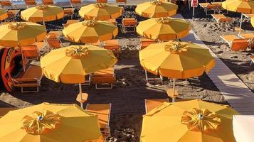 textura de sombrillas en la arena de la playa spotorno, en el oeste de liguria durante una mañana de verano en 2022 foto
