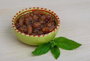 Mulberry jam in a bowl on wooden background photo