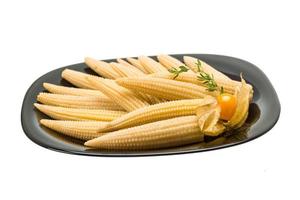 Baby corn on the plate and white background photo