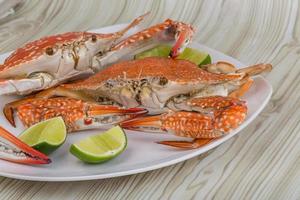 Boiled crabs on the plate and wooden background photo