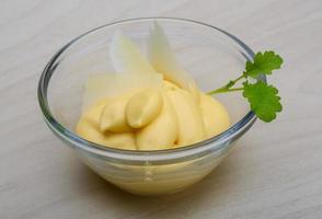 Cheese sauce in a bowl on wooden background photo