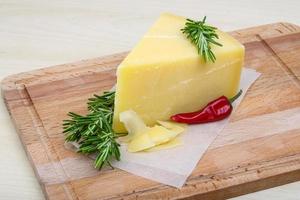 Parmesan cheese on wooden board and wooden background photo