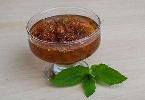 Mulberry jam in a bowl on wooden background photo