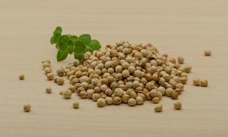 Coriander seeds on wooden background photo