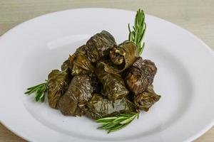 Dolma on the plate and wooden background photo