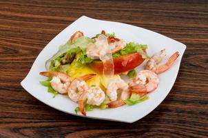 Shrimps with aloe vera salad on the plate and wooden background photo