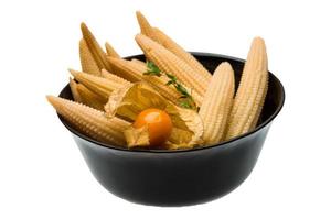 Baby corn in a bowl on white background photo