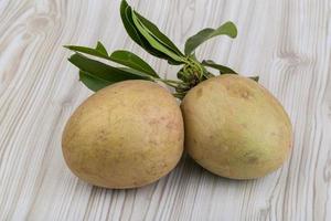 Sapodilla on wooden background photo