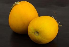 Small yellow melon on wooden background photo