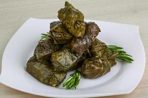Dolma on the plate and wooden background photo