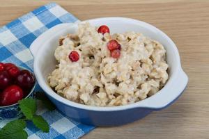 Oatmeal in a bowl on wooden background photo
