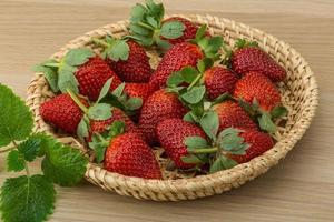 Fresh strawberry in a basket on wooden background photo