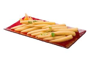 Baby corn on the plate and white background photo