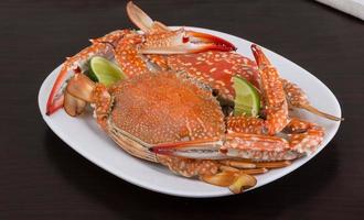 Boiled crabs on the plate and black background photo