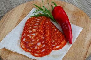 Chorizo on wooden board and wooden background photo