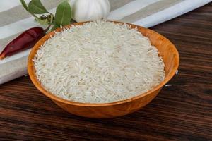 Basmati rice in a bowl on wooden background photo