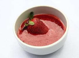 Strawberry puree in a bowl on white background photo