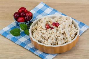 Oatmeal in a bowl on wooden background photo