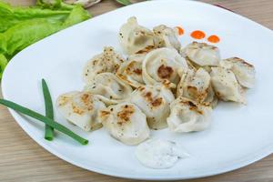 Roasted pierogi on the plate and wooden background photo