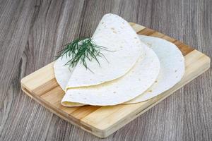 tortillas en tablero de madera y fondo de madera foto