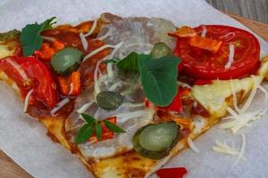 Pizza on wooden board and wooden background photo