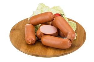 Sausages on wooden board and white background photo