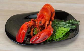 Red boiled lobster on the plate and wooden background photo