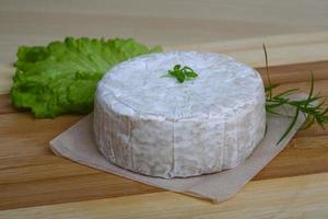 Brie cheese on wooden board and wooden background photo