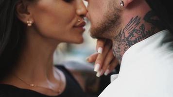 Young hip couple with tattoos embrace on a city street video